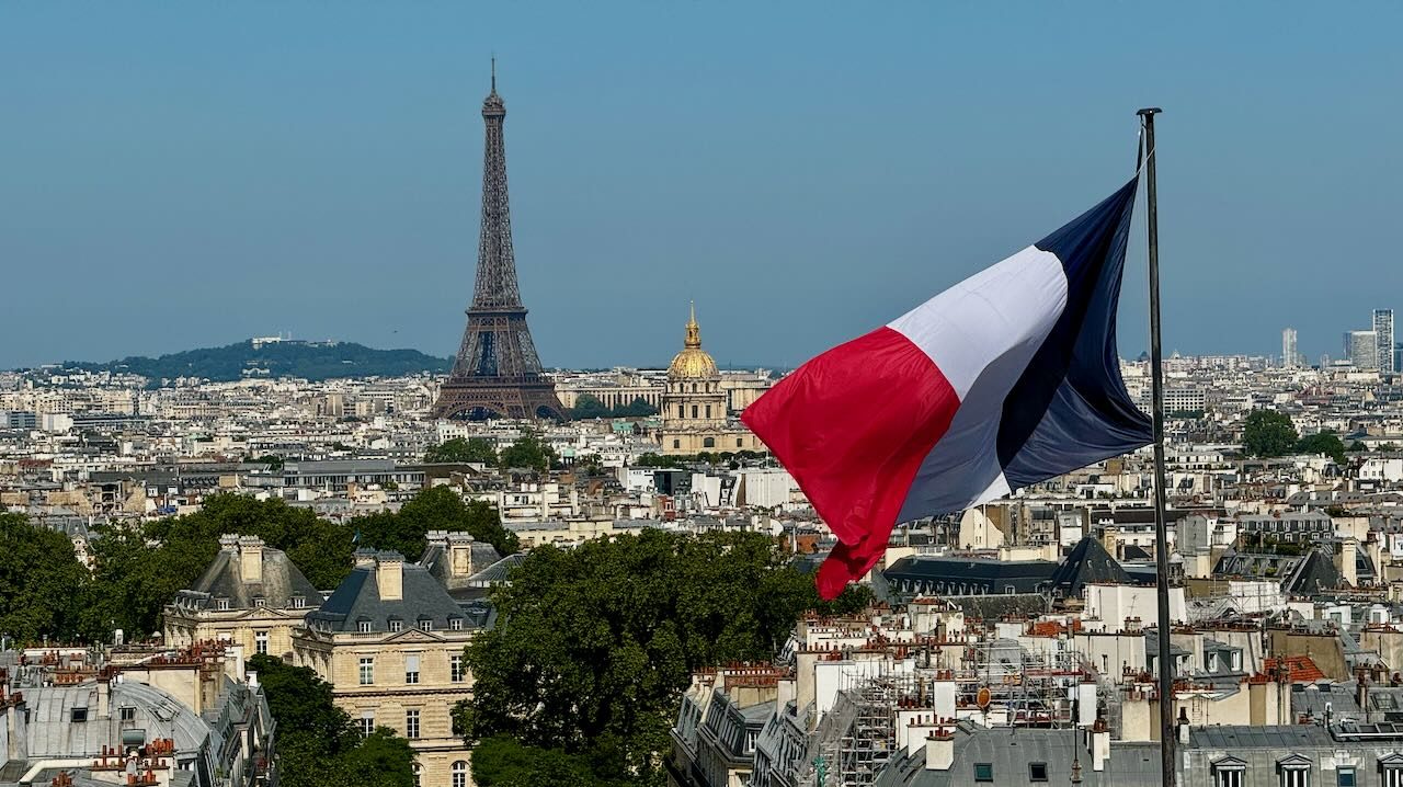 De wapperende franse vlag met op de achtergrond de Eiffeltoren