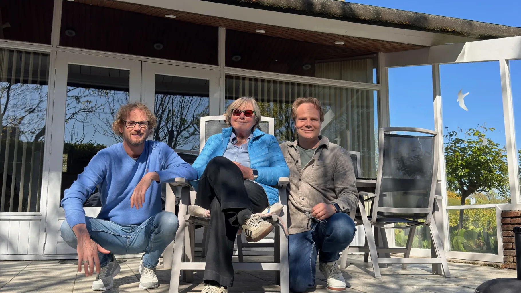 Jochem, Jannie en Michiel zitten naast elkaar in de zon te poseren